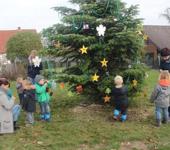 Kindergartenkinder schmücken Weihnachtsbaum in Varenholz